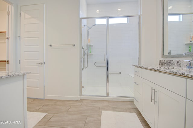 bathroom with tile patterned flooring, vanity, and a shower with door