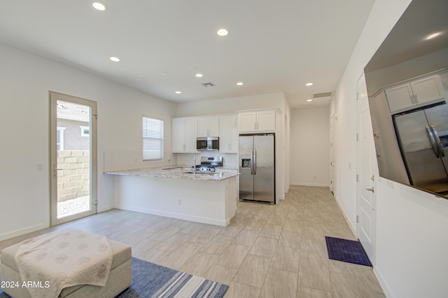 2228 E Isaiah Ave, Gilbert, AZ 85298 - kitchen featuring appliances with stainless steel finishes, a peninsula, white cabinets, recessed lighting, and light stone countertops