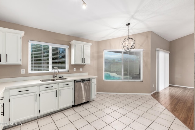 kitchen with white cabinetry, a sink, hanging light fixtures, light countertops, and dishwasher