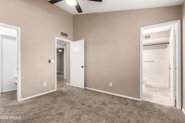 unfurnished bedroom featuring ensuite bath, carpet, visible vents, and baseboards