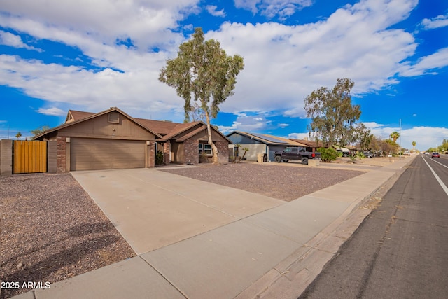 view of front of home featuring a gate, fence, concrete driveway, a garage, and brick siding