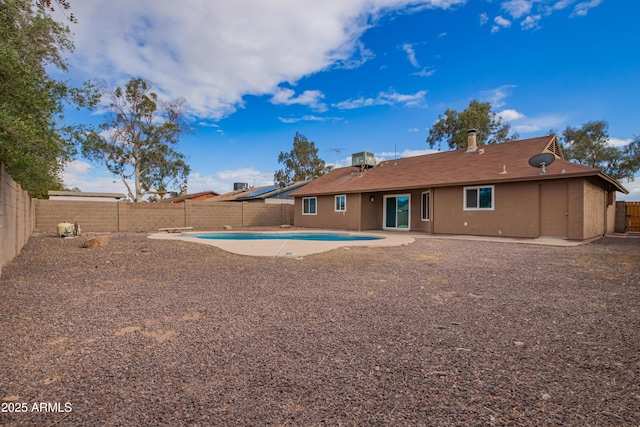 rear view of house featuring stucco siding, a fenced backyard, and a patio area