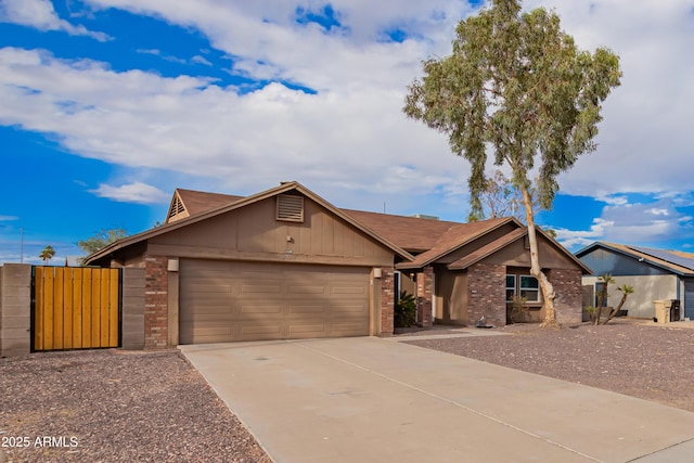 view of front of home with brick siding, board and batten siding, concrete driveway, a garage, and a gate