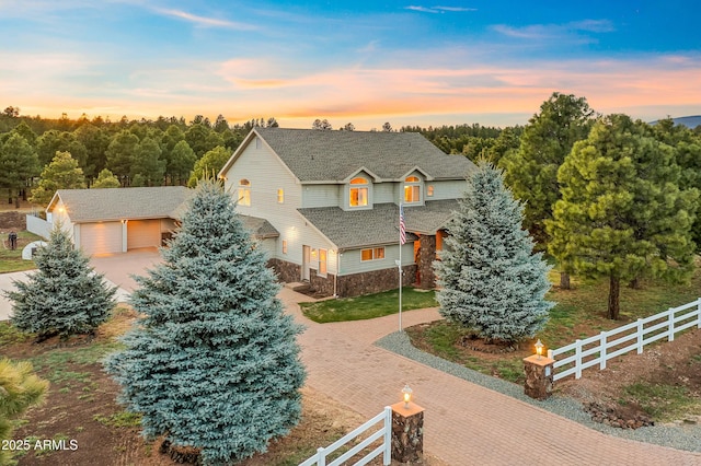 2705 W Creighton Dr, Flagstaff, AZ 86001 - view of front facade with an outbuilding, decorative driveway, stone siding, fence, and a shingled roof