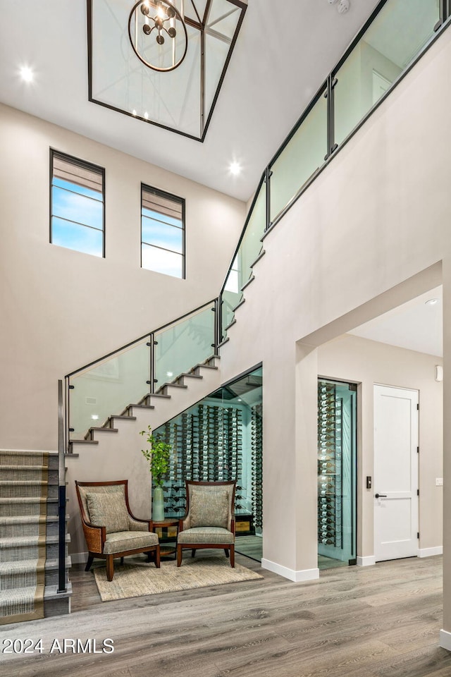 stairway with hardwood / wood-style flooring and a high ceiling