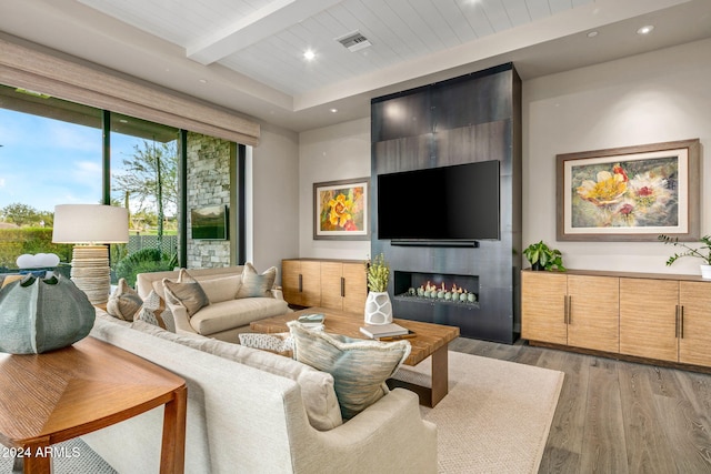 living room featuring a fireplace, beam ceiling, wooden ceiling, and light hardwood / wood-style flooring