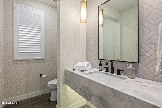 bathroom featuring toilet, hardwood / wood-style floors, and sink