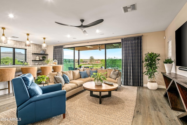 living room featuring ceiling fan and light hardwood / wood-style flooring