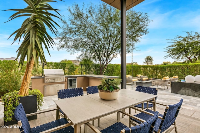 view of patio with area for grilling, beverage cooler, and exterior kitchen