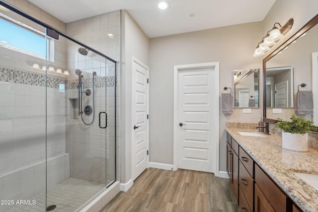 30342 N 130th Dr, Peoria, AZ 85383 - full bathroom with baseboards, a sink, a stall shower, double vanity, and wood finished floors
