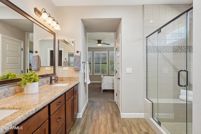 30342 N 130th Dr, Peoria, AZ 85383 - bathroom with connected bathroom, a stall shower, a sink, a ceiling fan, and wood finished floors
