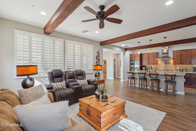 30342 N 130th Dr, Peoria, AZ 85383 - living area with visible vents, beamed ceiling, baseboards, wood finished floors, and a ceiling fan
