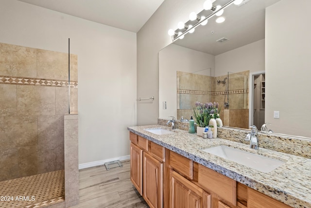 bathroom featuring tiled shower, hardwood / wood-style flooring, and vanity