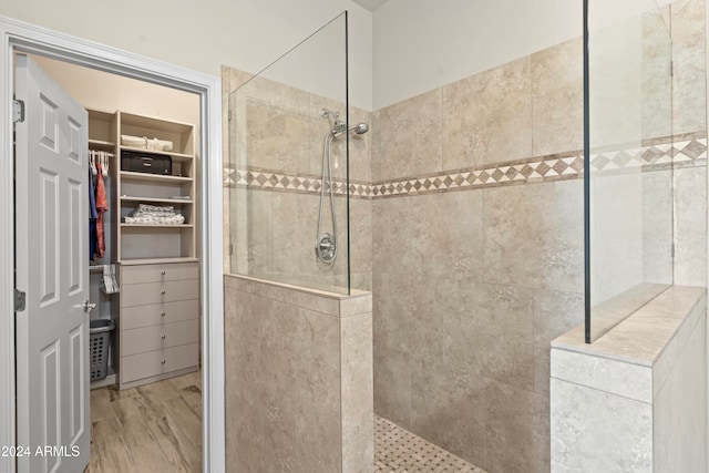 bathroom featuring hardwood / wood-style floors and tiled shower