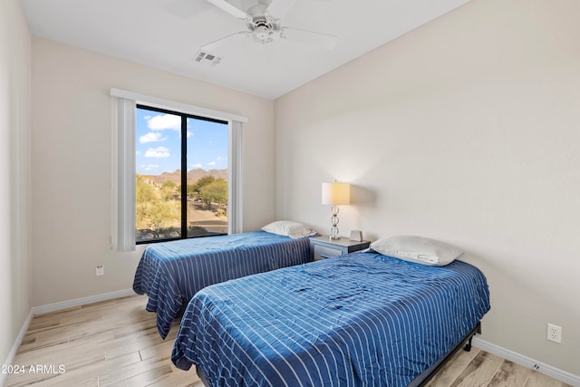 bedroom with ceiling fan, light hardwood / wood-style flooring, and vaulted ceiling