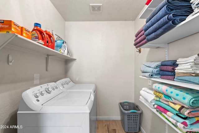 washroom with hardwood / wood-style floors and washer and dryer