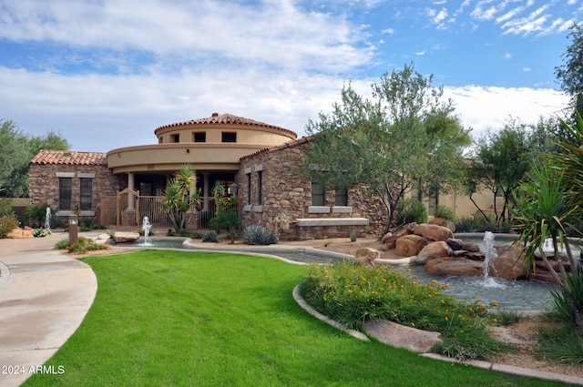 mediterranean / spanish house featuring a front lawn