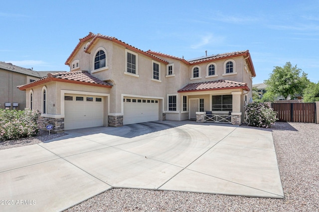 2726 S 160th Ave, Goodyear, AZ 85338 - mediterranean / spanish home with stone siding, fence, a garage, a tiled roof, and concrete driveway