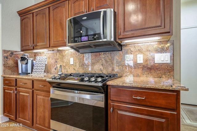 2726 S 160th Ave, Goodyear, AZ 85338 - kitchen featuring stainless steel gas range oven, light stone countertops, brown cabinetry, and backsplash
