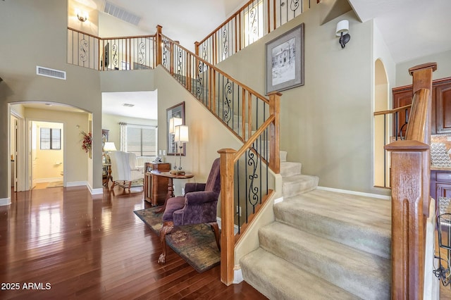 2726 S 160th Ave, Goodyear, AZ 85338 - staircase featuring arched walkways, wood finished floors, baseboards, and a high ceiling