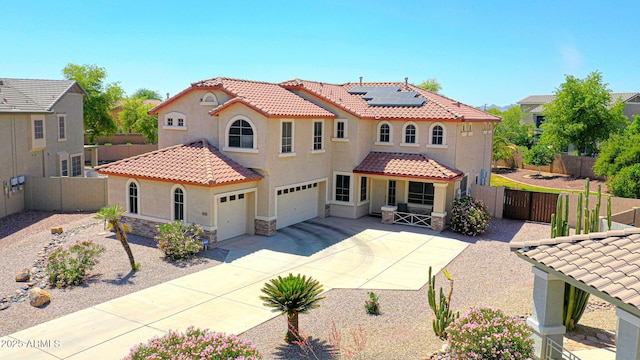2726 S 160th Ave, Goodyear, AZ 85338 - mediterranean / spanish house featuring a tile roof, stucco siding, roof mounted solar panels, a garage, and a gate