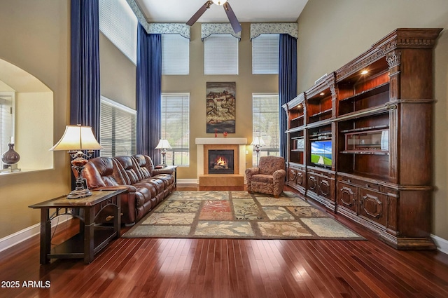 2726 S 160th Ave, Goodyear, AZ 85338 - living room with a high ceiling, a fireplace, a ceiling fan, hardwood / wood-style floors, and baseboards