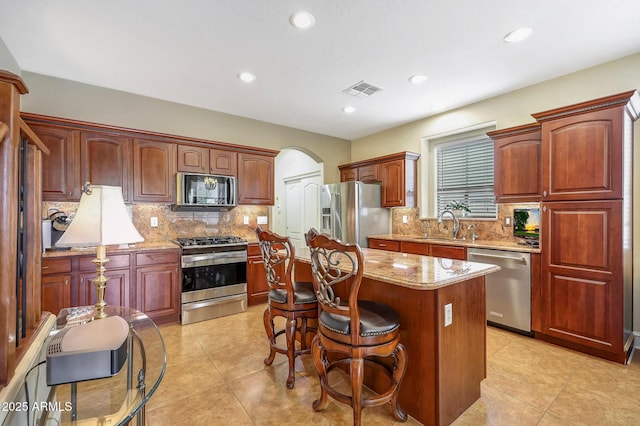 2726 S 160th Ave, Goodyear, AZ 85338 - kitchen featuring stainless steel appliances, a sink, a center island, decorative backsplash, and recessed lighting