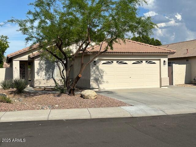 20275 N 81st Ln, Peoria, AZ 85382 - view of front of house with concrete driveway, a garage, a tiled roof, and stucco siding