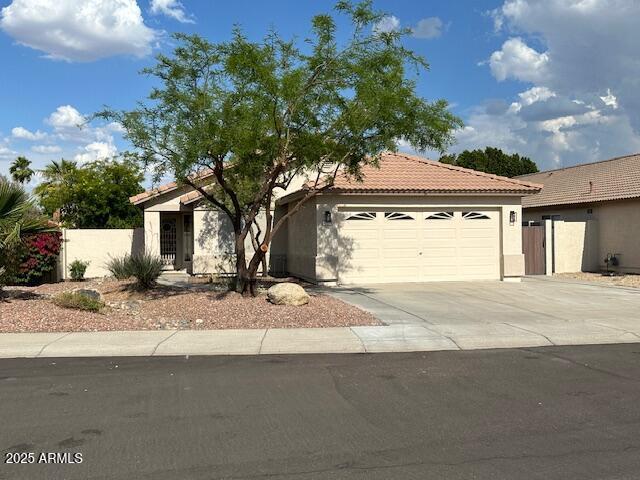 20275 N 81st Ln, Peoria, AZ 85382 - view of front of home featuring a garage, driveway, a tiled roof, stucco siding, and fence