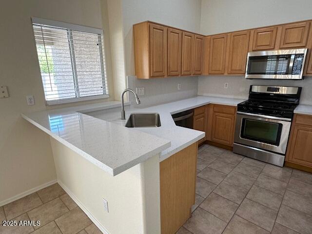 20275 N 81st Ln, Peoria, AZ 85382 - kitchen featuring appliances with stainless steel finishes, a sink, a peninsula, and light tile patterned floors