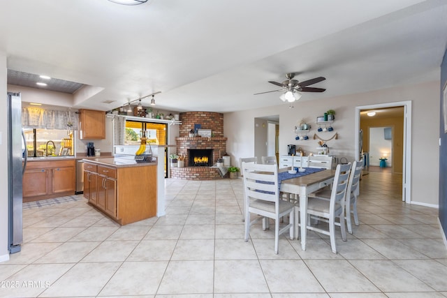 kitchen featuring appliances with stainless steel finishes, a center island, light tile patterned floors, and sink