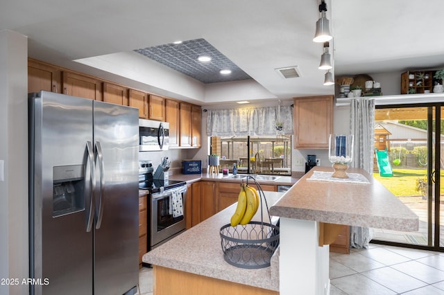 kitchen with sink, hanging light fixtures, a healthy amount of sunlight, and appliances with stainless steel finishes