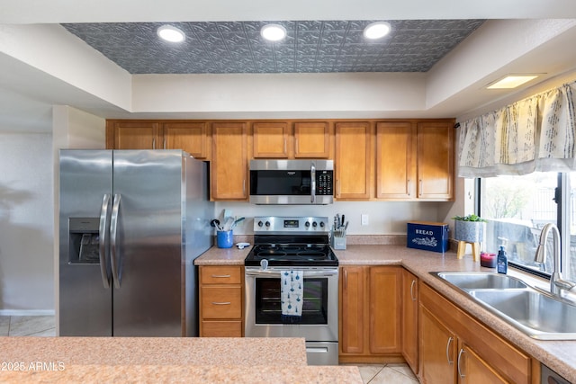 kitchen featuring stainless steel appliances, light tile patterned flooring, and sink