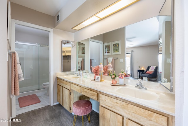 bathroom with vanity, tile patterned flooring, toilet, and walk in shower