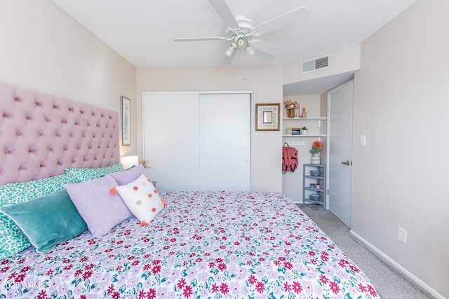 carpeted bedroom with ceiling fan and a closet