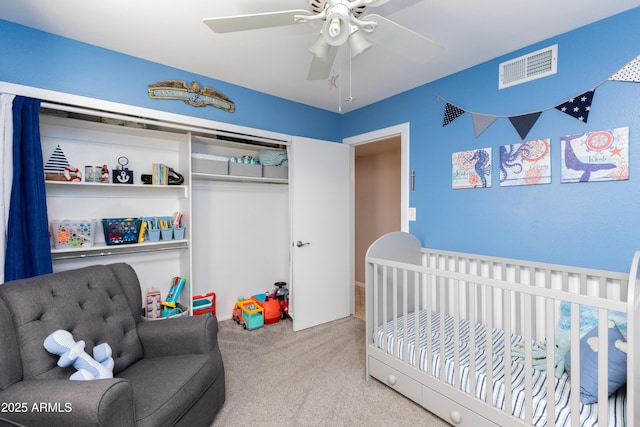 carpeted bedroom with ceiling fan and a closet