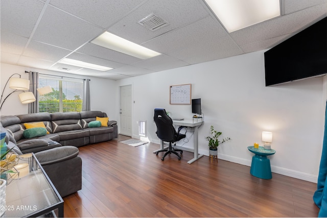 office space with dark wood-type flooring and a drop ceiling