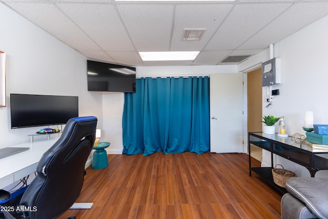 office area featuring a paneled ceiling and dark hardwood / wood-style flooring