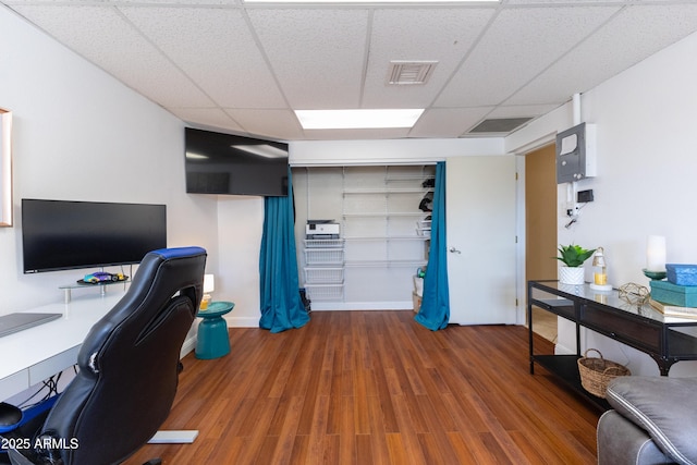 office area with dark hardwood / wood-style flooring and a drop ceiling