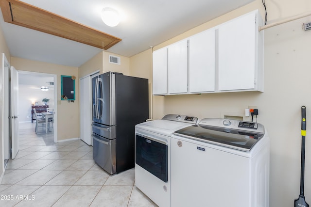 washroom with cabinets, separate washer and dryer, and light tile patterned floors