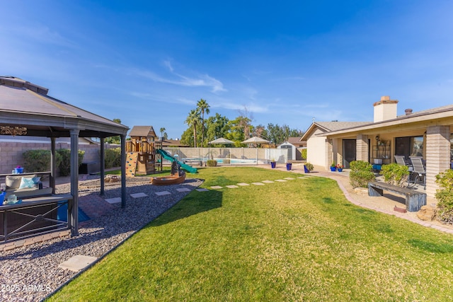 view of yard featuring a playground, a gazebo, and a pool