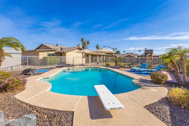 view of swimming pool featuring a diving board and a patio area