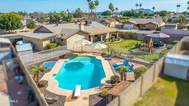 view of pool featuring a playground, a diving board, cooling unit, a gazebo, and a mountain view