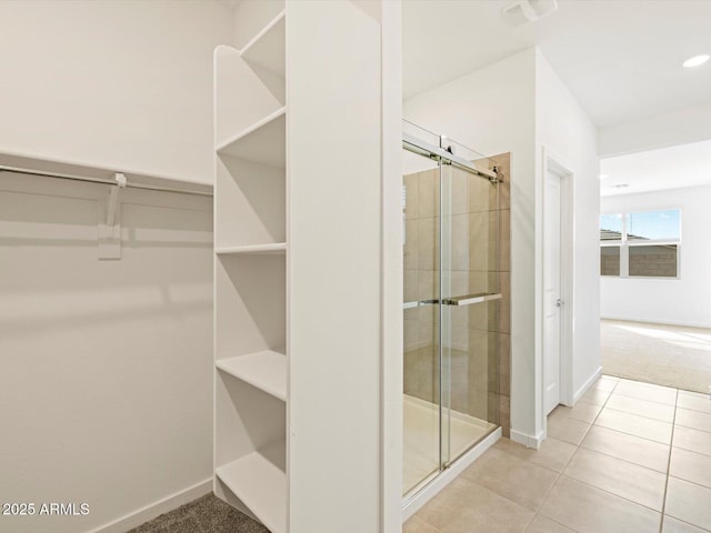 bathroom with walk in shower and tile patterned flooring