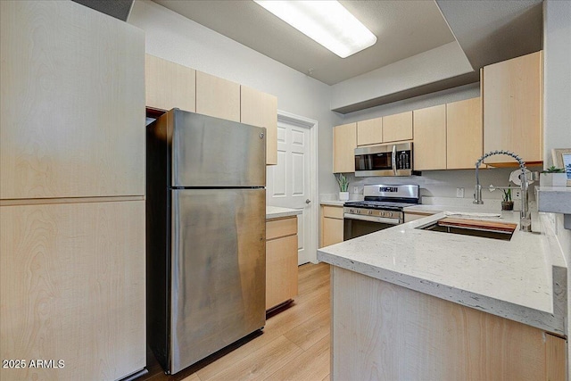 29606 N Tatum Blvd N Unit 265, Cave Creek, AZ 85331 - kitchen featuring stainless steel appliances, light brown cabinetry, light wood-style floors, and light stone countertops