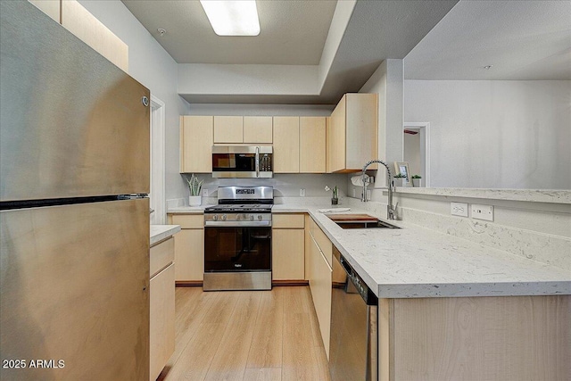 29606 N Tatum Blvd N Unit 265, Cave Creek, AZ 85331 - kitchen with appliances with stainless steel finishes, light brown cabinets, light wood-type flooring, and a peninsula
