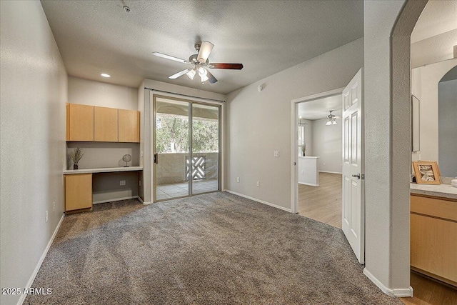 29606 N Tatum Blvd N Unit 265, Cave Creek, AZ 85331 - unfurnished living room with a ceiling fan, arched walkways, light colored carpet, and a textured ceiling