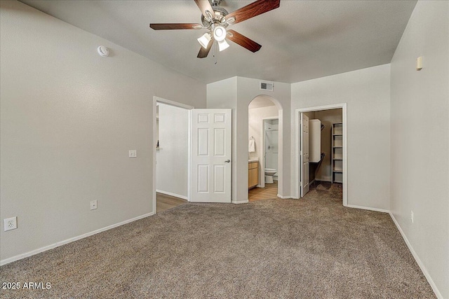 29606 N Tatum Blvd N Unit 265, Cave Creek, AZ 85331 - unfurnished bedroom featuring arched walkways, carpet floors, a walk in closet, connected bathroom, and ceiling fan