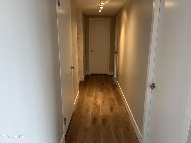 hallway featuring wood finished floors and baseboards