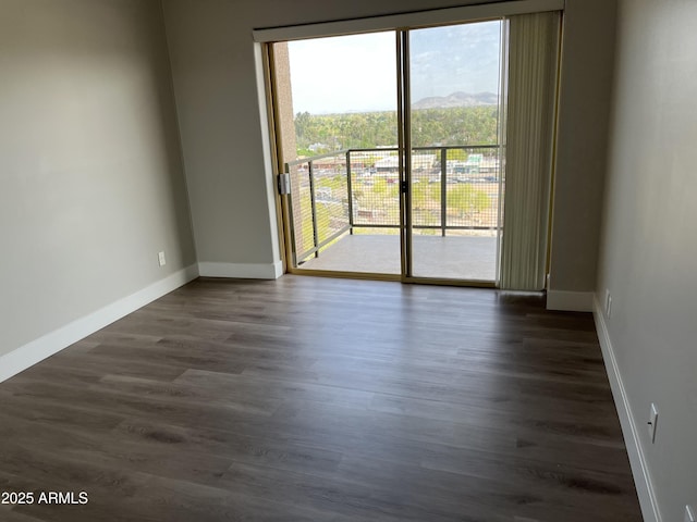 empty room with baseboards and dark wood finished floors